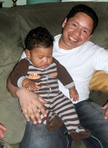 Enrique holds his nearly nine month old son, Daniel Enrique