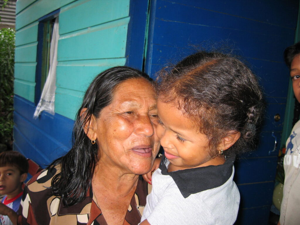 Enrique's paternal grandmother María stands in front of her Tegucigalpa home and holds Jasmín in 2003.