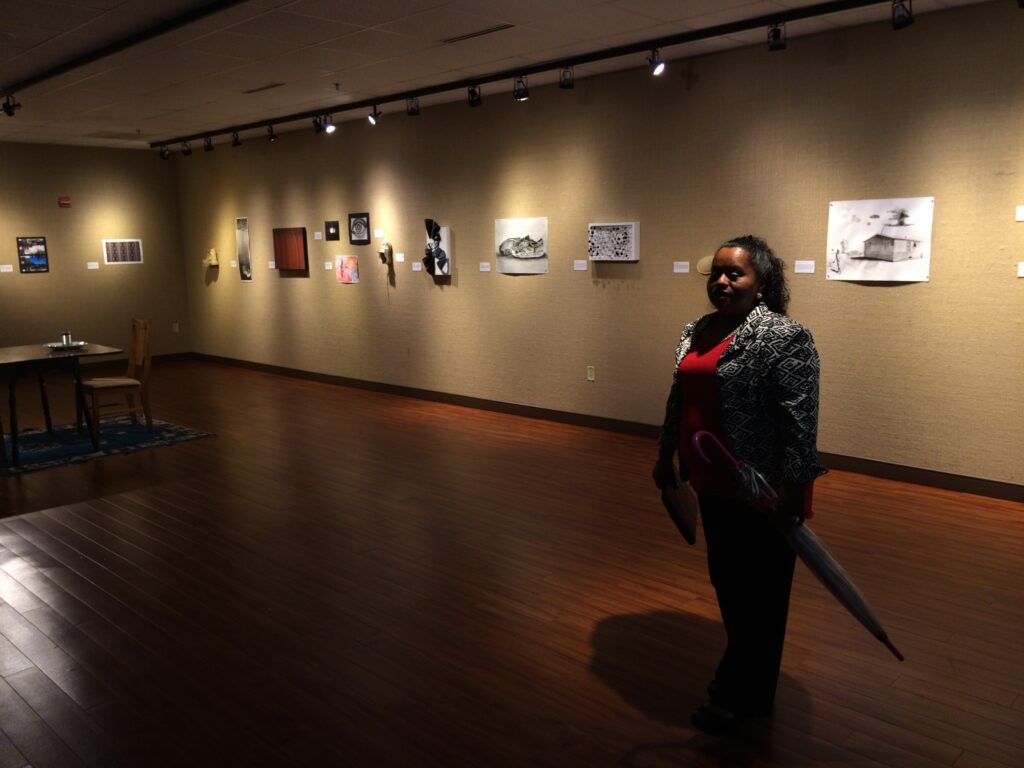 Lourdes viewing art inspired by Enrique's Journey at Sam Houston State University, November 2015. [Credit: Sonia Nazario]